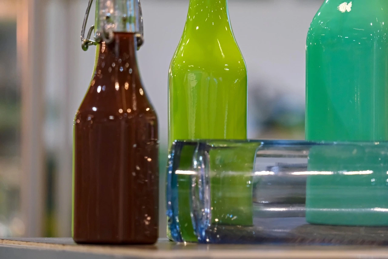 drei Flaschen aus Glas, befüllt mit verschiedenfarbigen Säften