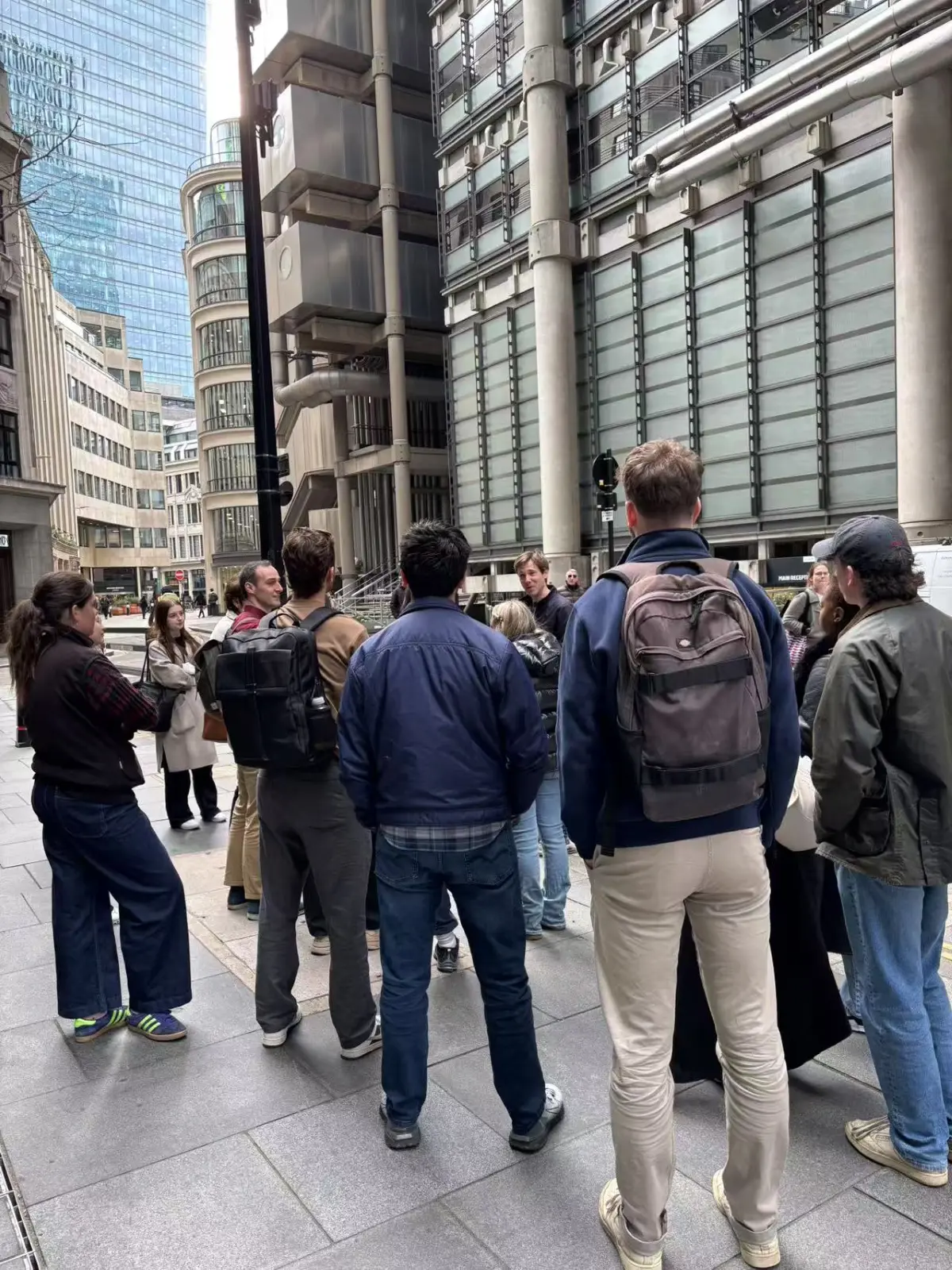 A
  group
  of
  people
  standing
  on
  the
  sidewalk
  Description
  automatically
  generated