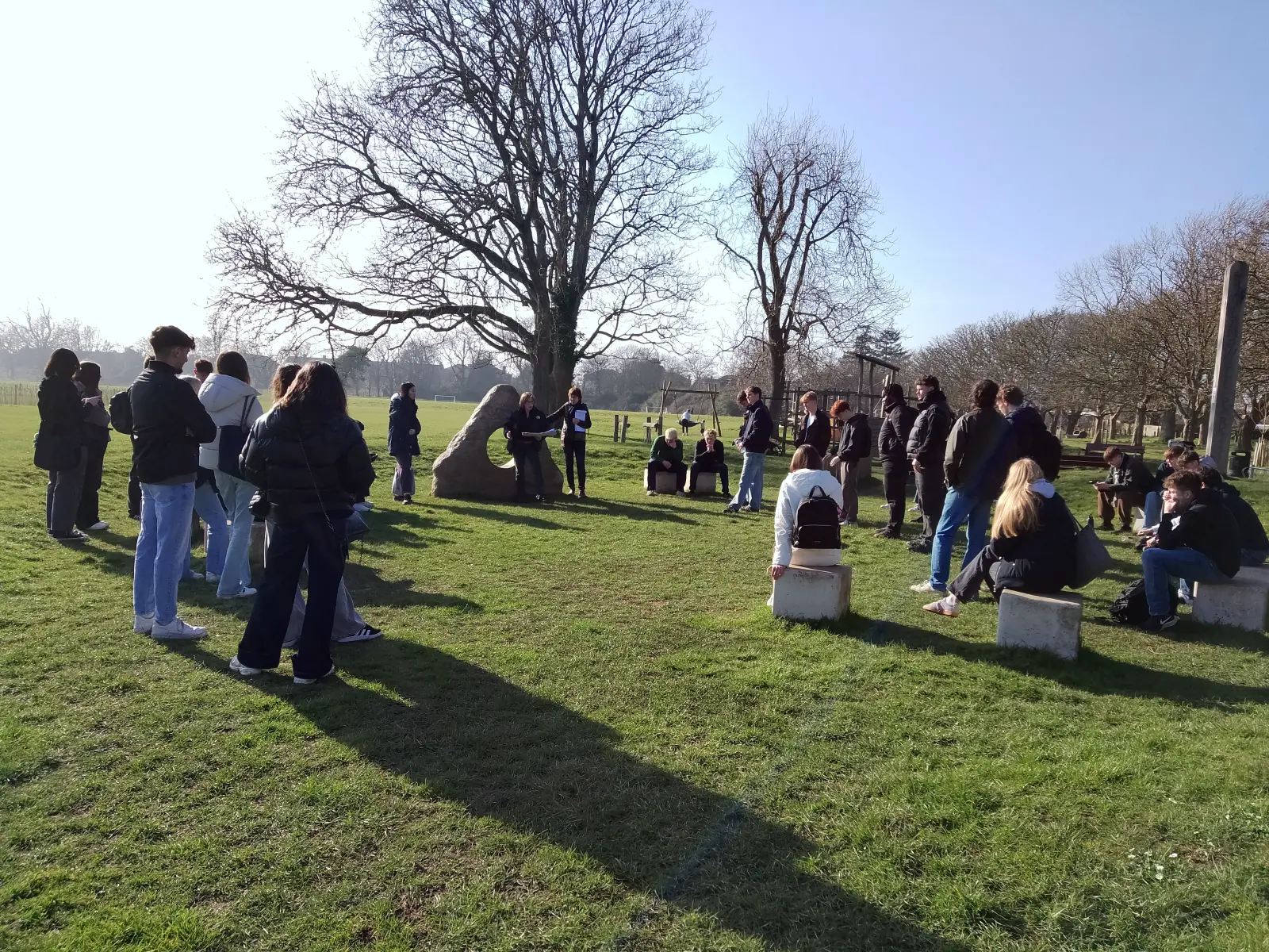 A
  group
  of
  people
  standing
  in
  a
  field
  Description
  automatically
  generated