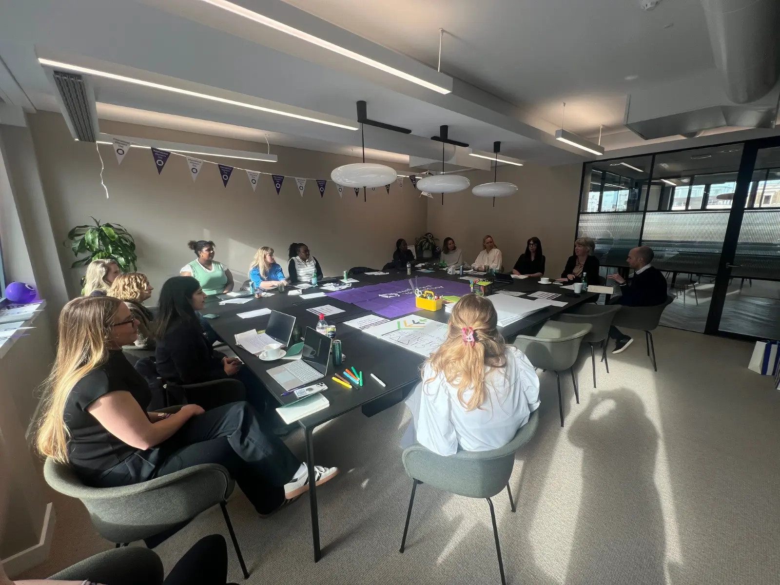 A
  group
  of
  people
  sitting
  around
  a
  table
  Description
  automatically
  generated