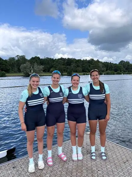 A
  group
  of
  women
  wearing
  uniforms
  standing
  on
  a
  dock
  Description
  automatically
  generated