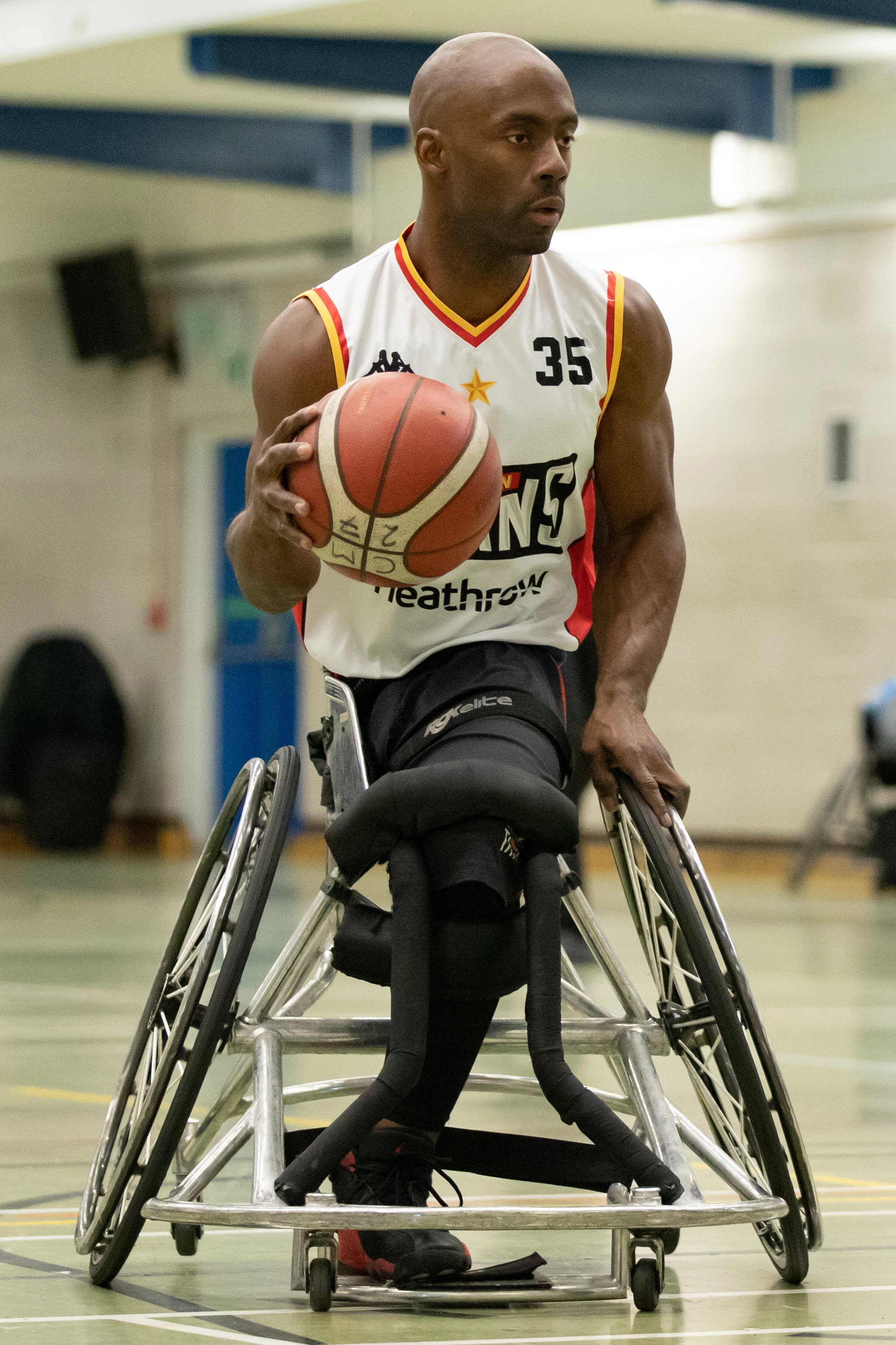 Men sitting in a wheelchair playing basketball