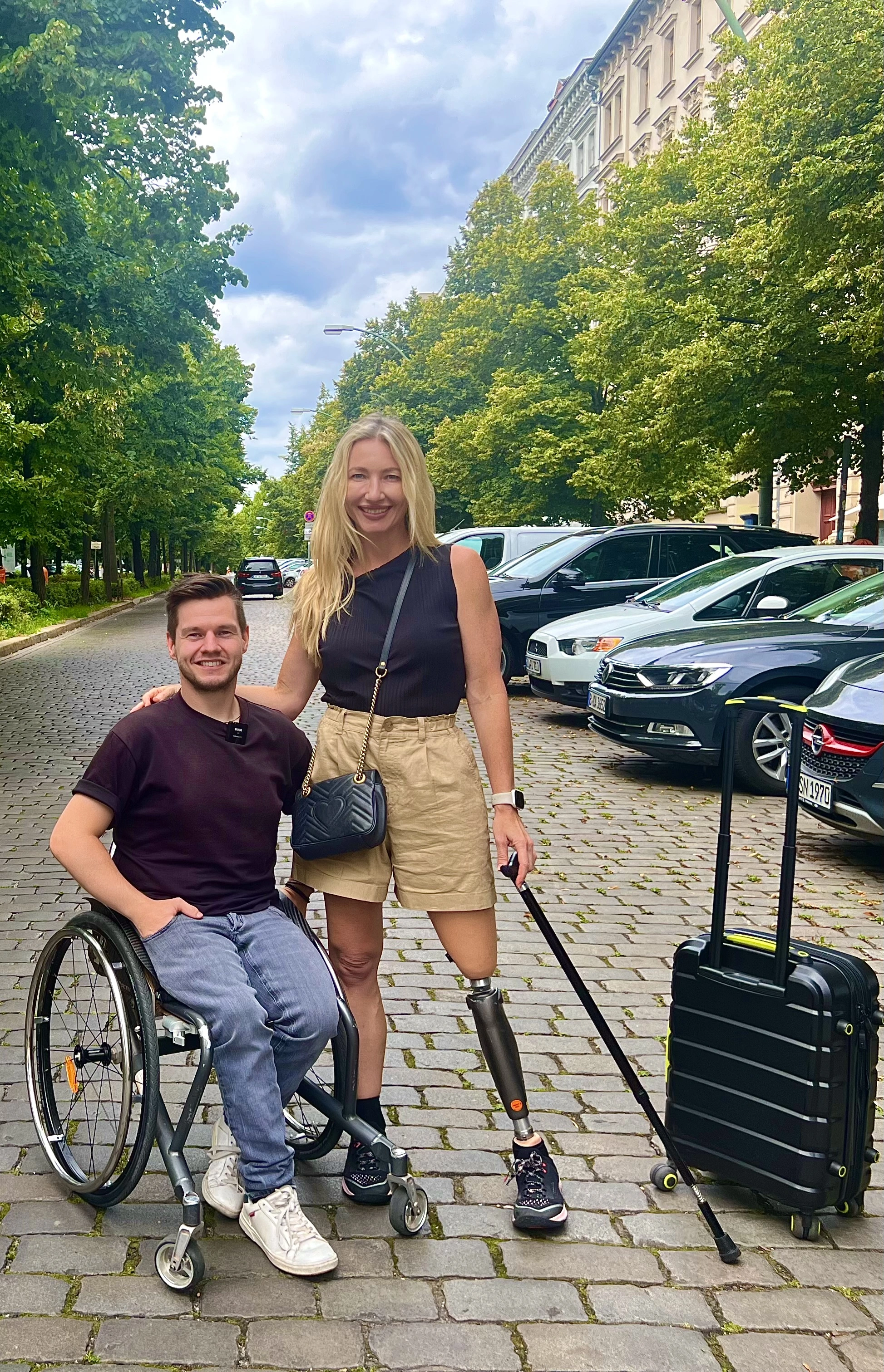 men in a wheelchair and women with a prosthesis posing on the street