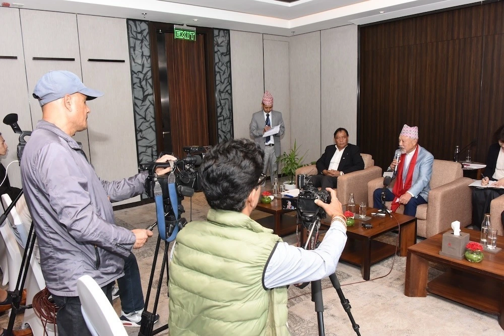 Yohei Sasakawa is speaking at a press conference joined by some 15 journalists.