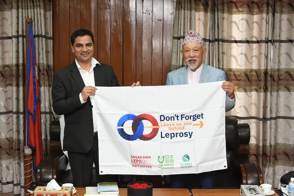 Yohei Sasakawa with Health and Population Minister Pradip Paudel with a "Don't Forget Leprosy” banner.