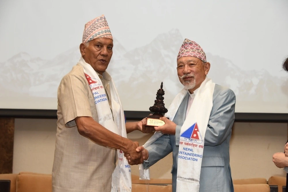 Being presented with a bronze trophy as a token of NMA’s appreciation for The Nippon Foundation’s support for Nepal’s fight against COVID-19 by former Tourism Minister Bal Bahadur Kc. (left).