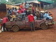 A group of children sitting on top of a truck in Cameroon