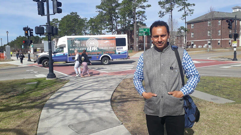 Mohan at the university campus along with the shuttle of UNCW